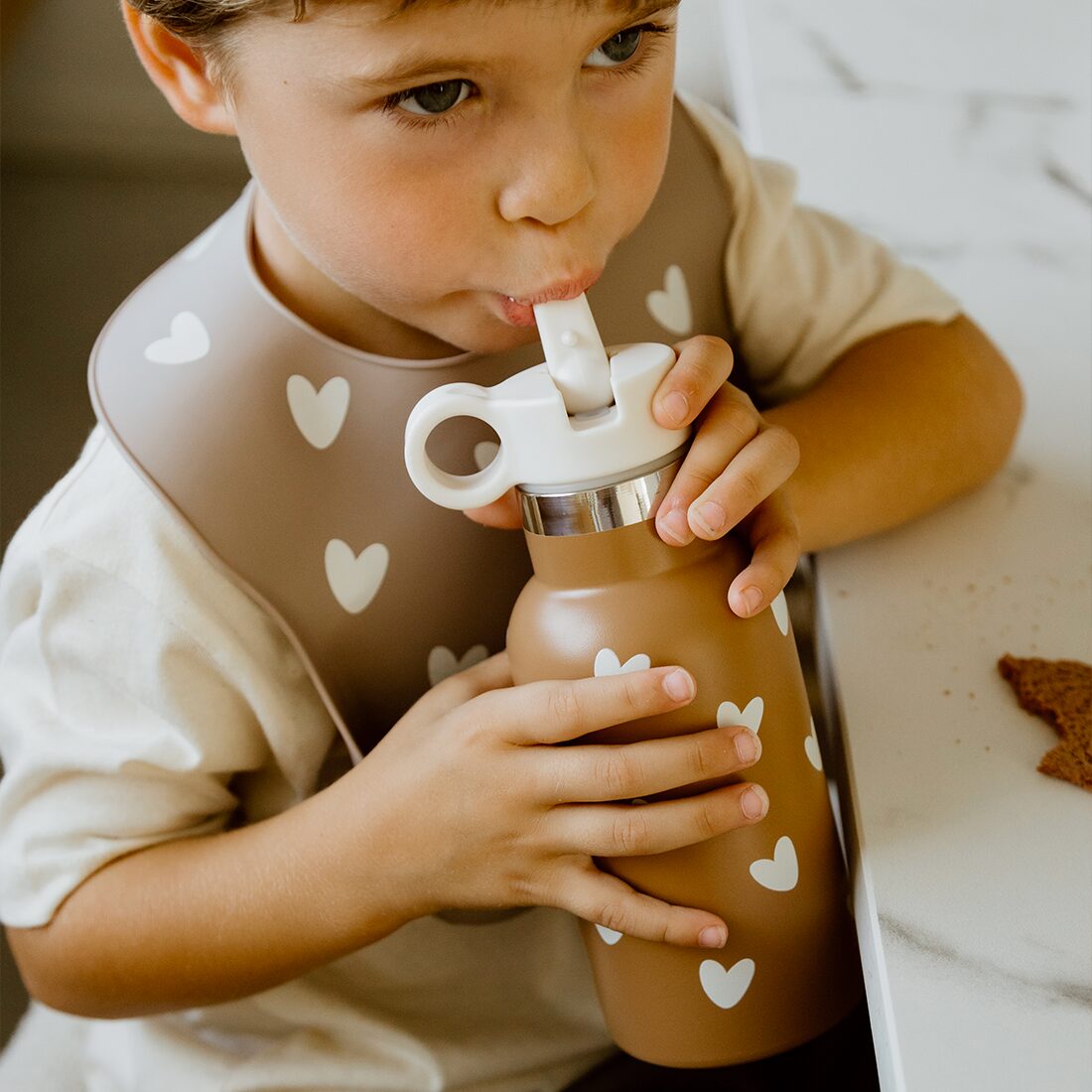 gourde-atelier-wagram-caramel-le-beguin-de-charlie gourde isotherme en acier inoxydable et bavoir silicone avec des motifs coeur pour bebe et enfant, repas atelier Wagram, le béguin de Charlie, Tours